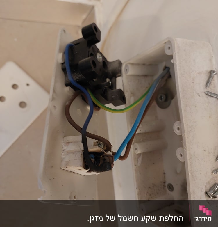 חוטי חשמל צבעוניים מחוברים לשקע פתוח